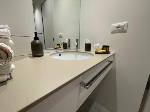 a white bathroom with a sink and a mirror at Torino48 Guesthouse in Milan
