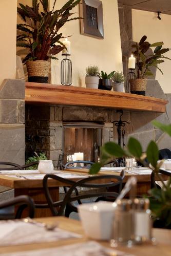 a restaurant with tables and chairs with a fireplace at Hotel Skalny in Zakopane