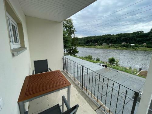 uma varanda com uma mesa e vista para um rio em Ferienwohnung Pirna mit Elbblick em Pirna