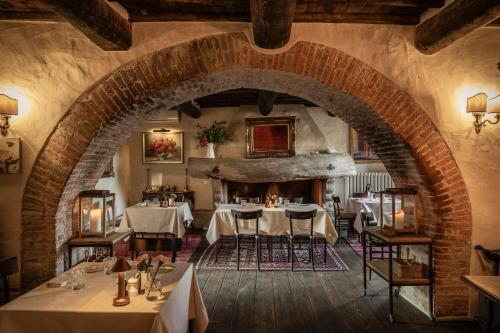 a dining room with tables and a stone archway at Lupaia in Montepulciano