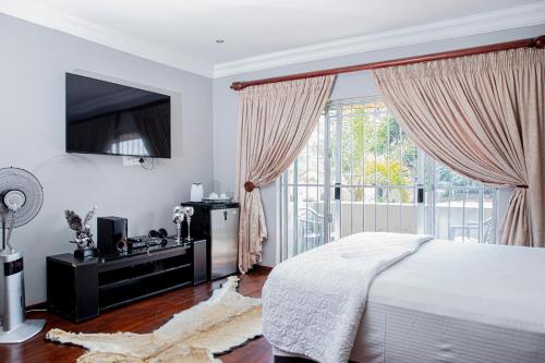 a bedroom with a bed and a large window at The Afropolitan in Johannesburg