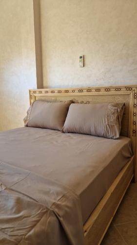 a large bed with a wooden headboard in a room at Apartamentos Khalifa C1 in Saïdia