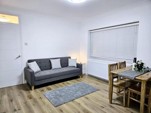 a living room with a couch and a table at Wonderful Apartment in Wembley in London