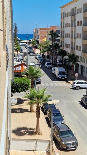 a street with cars parked in a parking lot at Apartamentos Khalifa C1 in Saïdia