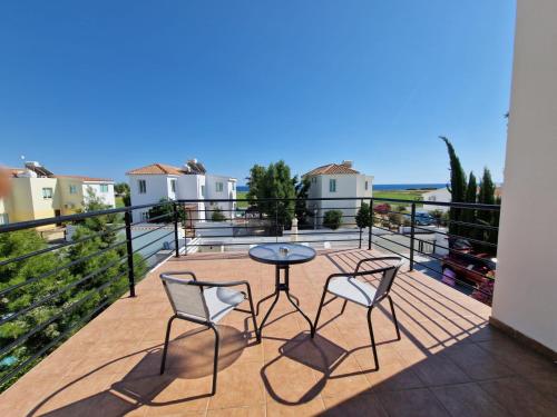 a patio with two chairs and a table on a balcony at Mandria Villa in Paphos in Mandria