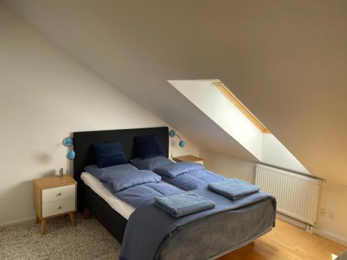 una camera da letto con un letto con cuscini blu di Velindrettet rækkehus med fantastisk udsigt a Næstved