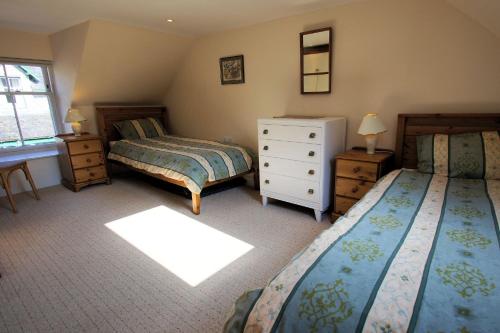 een slaapkamer met 2 bedden, een dressoir en een raam bij Tolsta in Killin