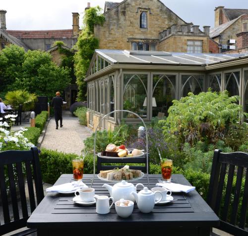 a black table with food on it in a garden at The Manor House Hotel in Moreton in Marsh