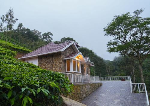 a house on a hill with a driveway at Tiyans Stone Castle Private Tea Villa Vagamon by VOYE HOMES in Vagamon