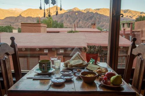 una mesa con comida y vistas a las montañas en Antigua Tilcara en Tilcara