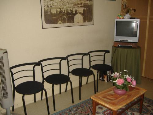 a group of chairs in a room with a tv at Residência Ideal in Coimbra