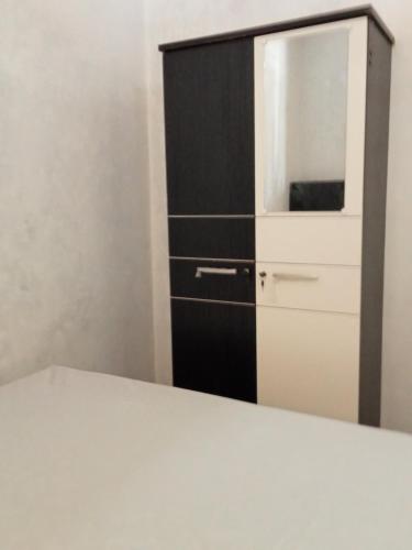 un armario blanco y negro con microondas en Homestay Miracle, en Rinondoran