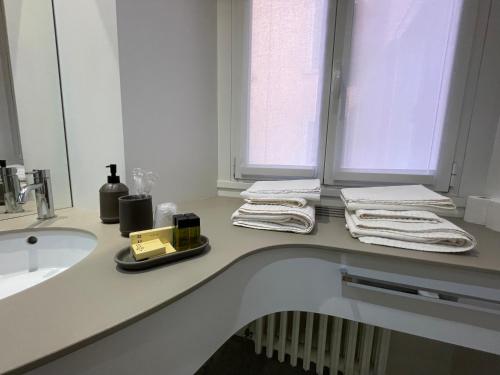 a bathroom with towels on a counter next to a sink at Torino48 Guesthouse in Milan