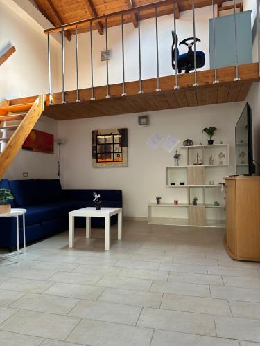 uma sala de estar com um sofá azul e uma mesa em Stylish Loft Trivano Cagliari 2 beds/2 bath em Cagliari