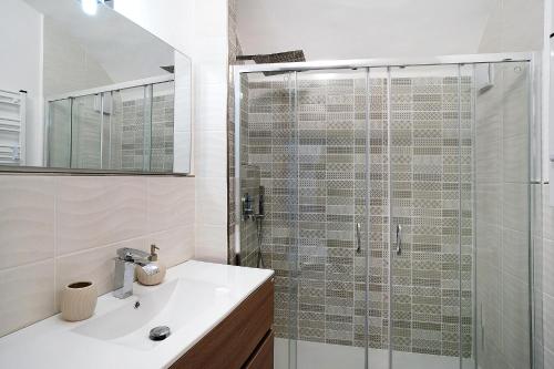 a bathroom with a sink and a glass shower at Casa di Ta in Sanremo