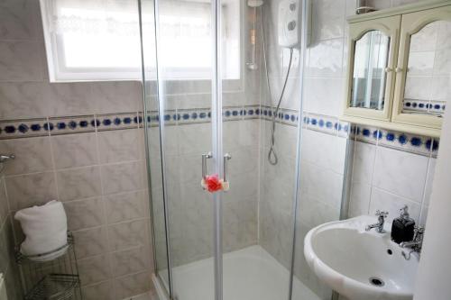 uma casa de banho com um chuveiro e um lavatório. em Luxurious Bedworth Exhall, House em Exhall
