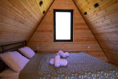 a bedroom with a bed in a wooden cabin at Panorama Racha in Ambrolauri