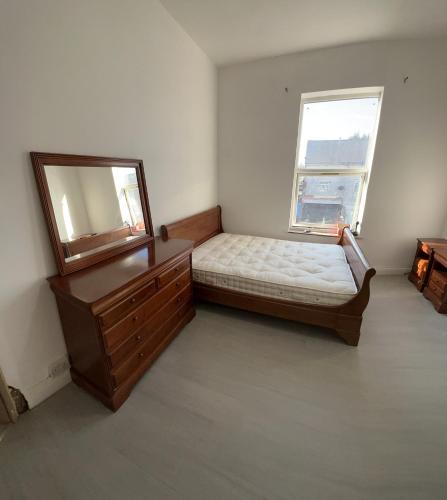 a bedroom with a bed and a mirror and a dresser at Large room in new flat - Walsall in Bescot