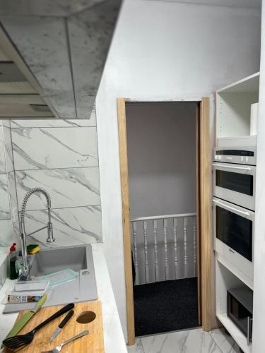 uma pequena cozinha com um lavatório e uma bancada em Large room in new flat - Walsall em Bescot