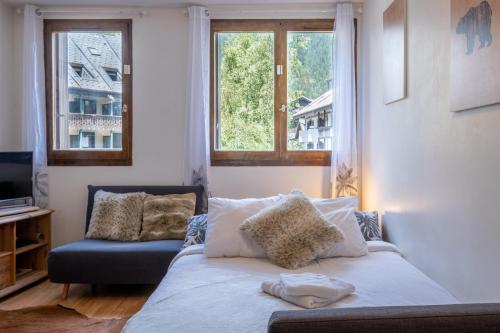 ein Wohnzimmer mit einem Sofa und 2 Fenstern in der Unterkunft City center studio next to Aguille du Midi lift in Chamonix-Mont-Blanc