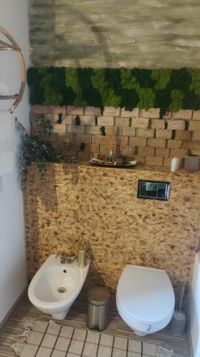 a bathroom with a toilet and a sink at Rooftop View in Predeluţ