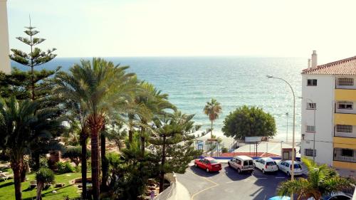 a group of cars parked in a parking lot next to the ocean at Apartamentos StarNerja II in Nerja