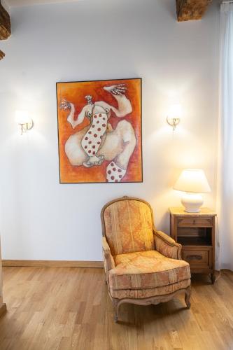 a living room with a chair and a painting on the wall at LE DOMAINE DE GORNETON in Chasse-sur-Rhône