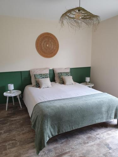 ein Schlafzimmer mit einem großen Bett mit grünen Wänden in der Unterkunft Le Cœur de la petite Cisse in Monteaux