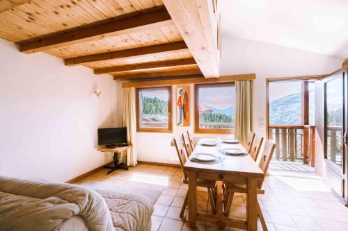 ブール・サン・モーリスにあるChalet cosyのテーブルと椅子と窓のあるリビングルーム