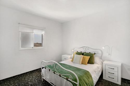 a white bedroom with a bed and a window at Los Morales in Arico