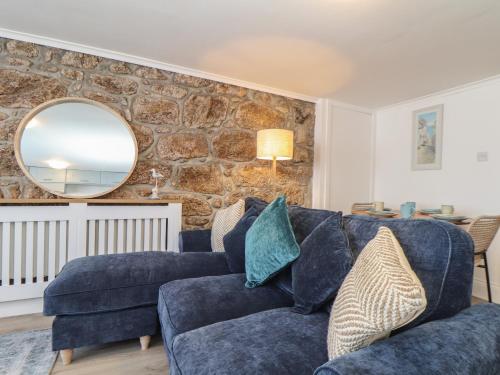 sala de estar con sofá azul y espejo en Harbour Studio en Penzance