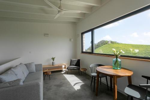 a living room with a couch and a table and a window at Solar Branco Eco Estate in Ponta Delgada