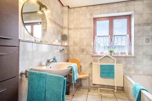 ein Badezimmer mit einem Waschbecken, einer Badewanne und einem Spiegel in der Unterkunft Drei-mädelhaus Ambs Wohnung 3 