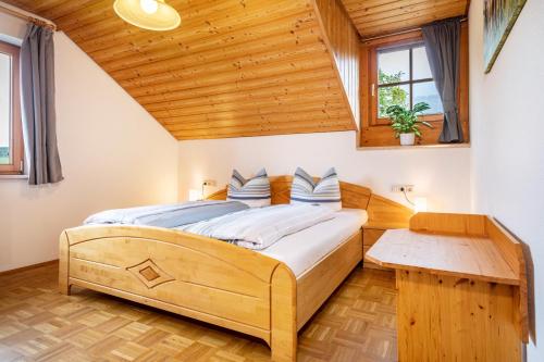 Schlafzimmer mit einem Holzbett und einem Holztisch in der Unterkunft Drei-mädelhaus Ambs Wohnung 3 