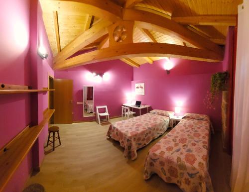1 dormitorio con 2 camas y techo de madera en Casa Atenea, en Zamora