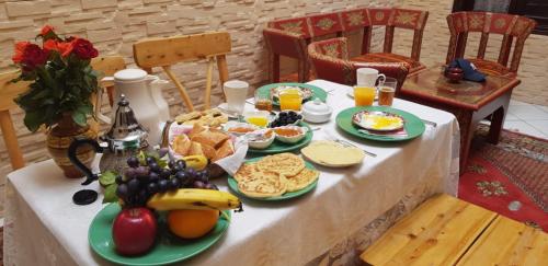 een tafel met borden eten en fruit erop bij Dar Suncial in Marrakesh