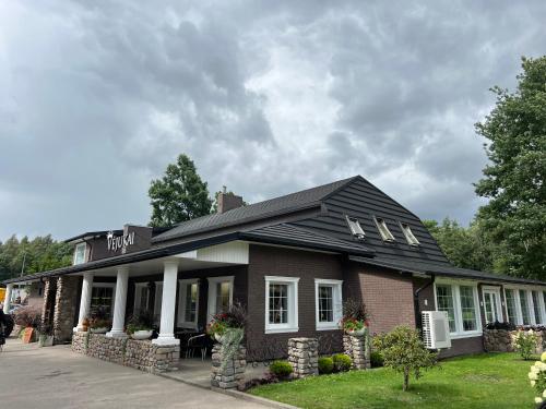 a brick building with a black roof at Vėjukai in Viduklė