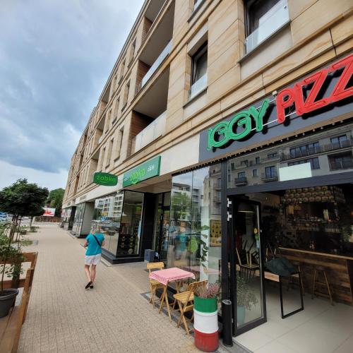 a woman walking in front of a store at Oskar Apartament Centrum PKP in Mińsk Mazowiecki