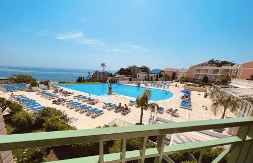 - une vue sur la piscine avec des chaises longues et l'océan dans l'établissement EXCEPTIONNEL sur CANNES vue mer piscine, à Cannes