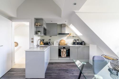 a kitchen with white cabinets and a staircase at Gorgeous Hampstead Flat in London