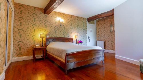 - une chambre avec un lit et du papier peint floral dans l'établissement Château Fombrauge, à Saint-Christophe-des-Bardes