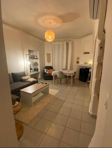 un salon avec un canapé et une table dans l'établissement Charmant appartement Ville médiévale, à Vaison-la-Romaine