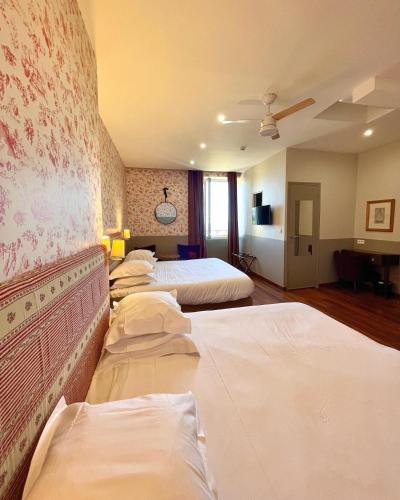 a row of beds in a hotel room at Hotel Restaurant Christophe Colomb in Calvi
