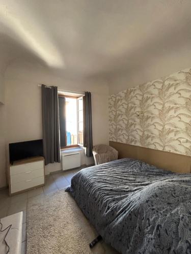une chambre avec un lit et une fenêtre dans l'établissement Charmant appartement Ville médiévale, à Vaison-la-Romaine