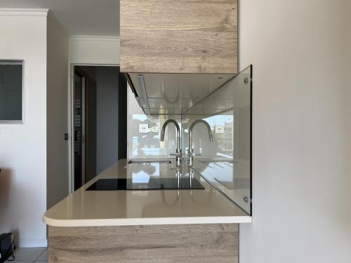 une cuisine avec un comptoir en verre avec un évier dans l'établissement EXCEPTIONNEL sur CANNES vue mer piscine, à Cannes
