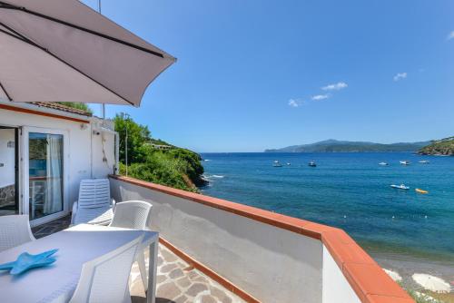 a balcony with a table and chairs and the ocean at Villa Oda - Trilocale sul mare in Capoliveri