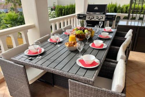 un tavolo con bicchieri da cibo e vino su un patio di Casa Rose - 4-Bed villa with private pool in Calpe a Calpe