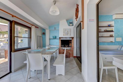 a kitchen with a table and chairs and a fireplace at Villa Oda - Trilocale sul mare in Capoliveri