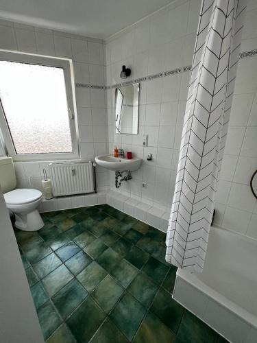 a bathroom with a toilet and a sink at Aventura Flat 1 in Bremen