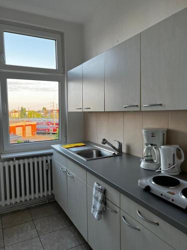 a kitchen with a sink and a window at Aventura Flat 1 in Bremen